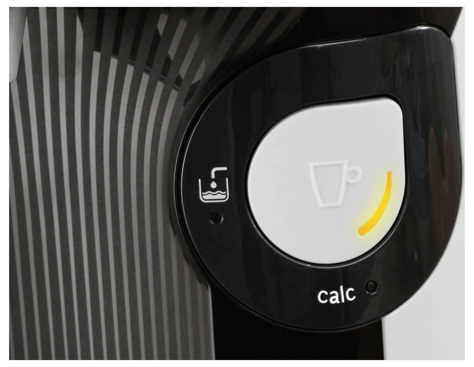Detail ovládacího panelu kávovaru, který zobrazuje tlačítko s ikonou šálku, žlutou signalizační kontrolku a symbol 'calc'.