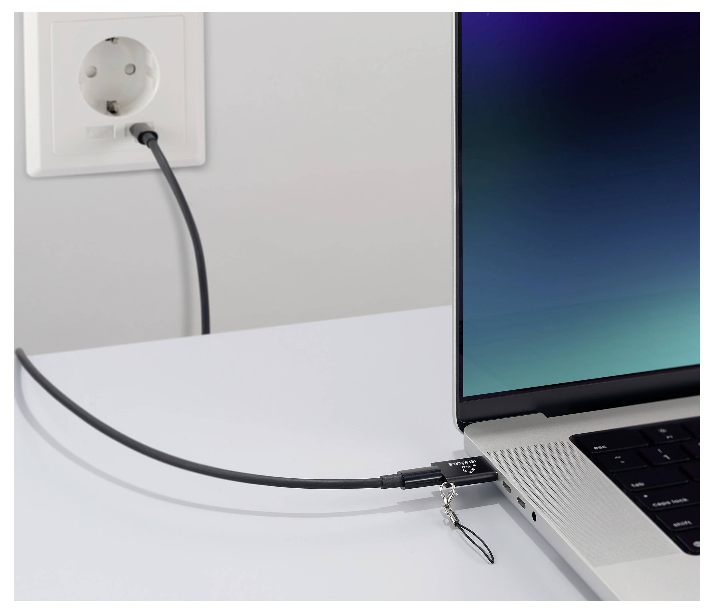 Přenosný počítač je připojen k elektrické zásuvce prostřednictvím bezpečnostního kabelového zámku, který zabraňuje jeho krádeži během používání.