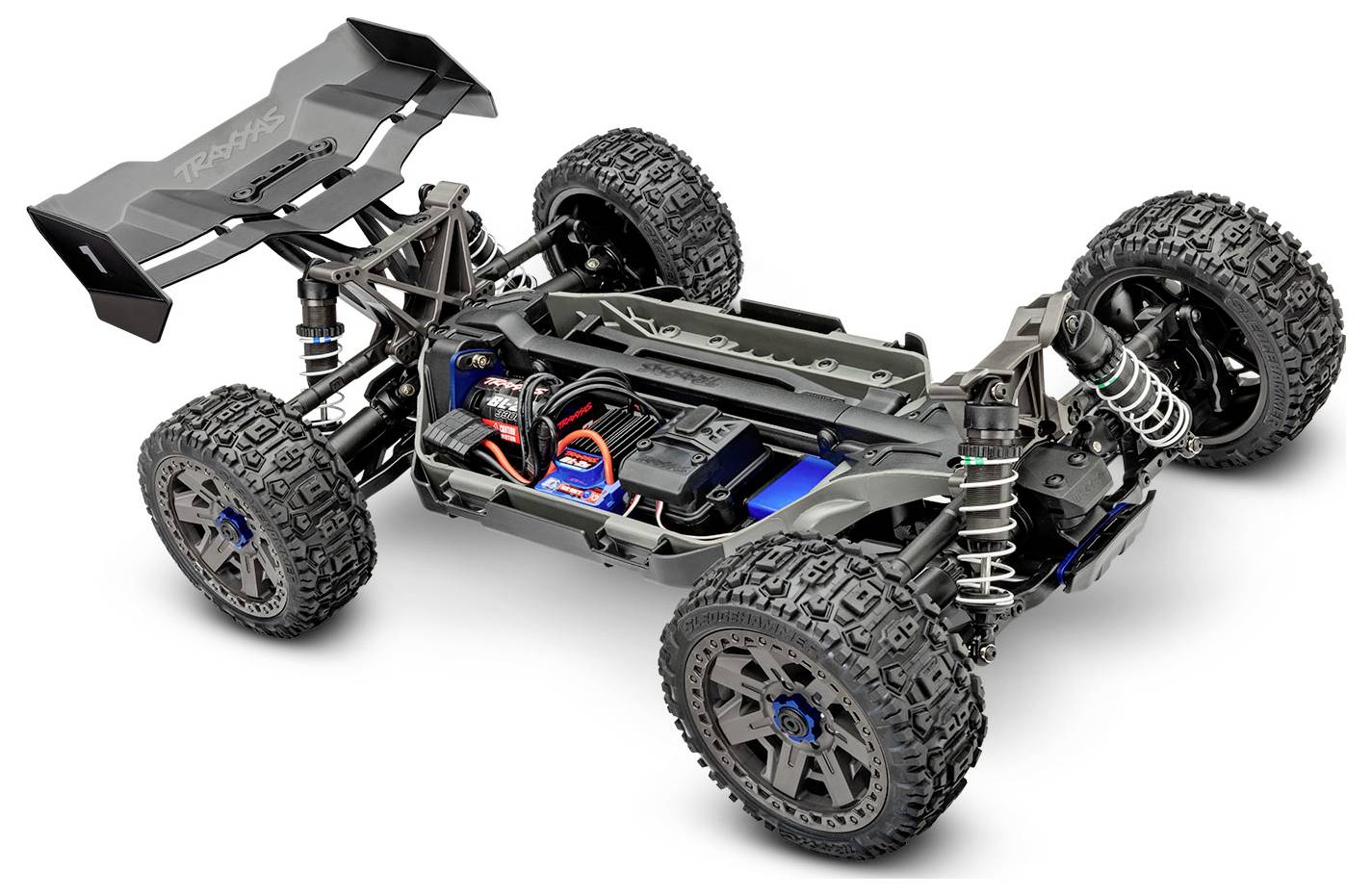 Detailní pohled na podvozek terénního RC modelu auta zobrazující velké pneumatiky, zavěšení, motor a elektroniku se zaměřením na design a funkcionalitu.