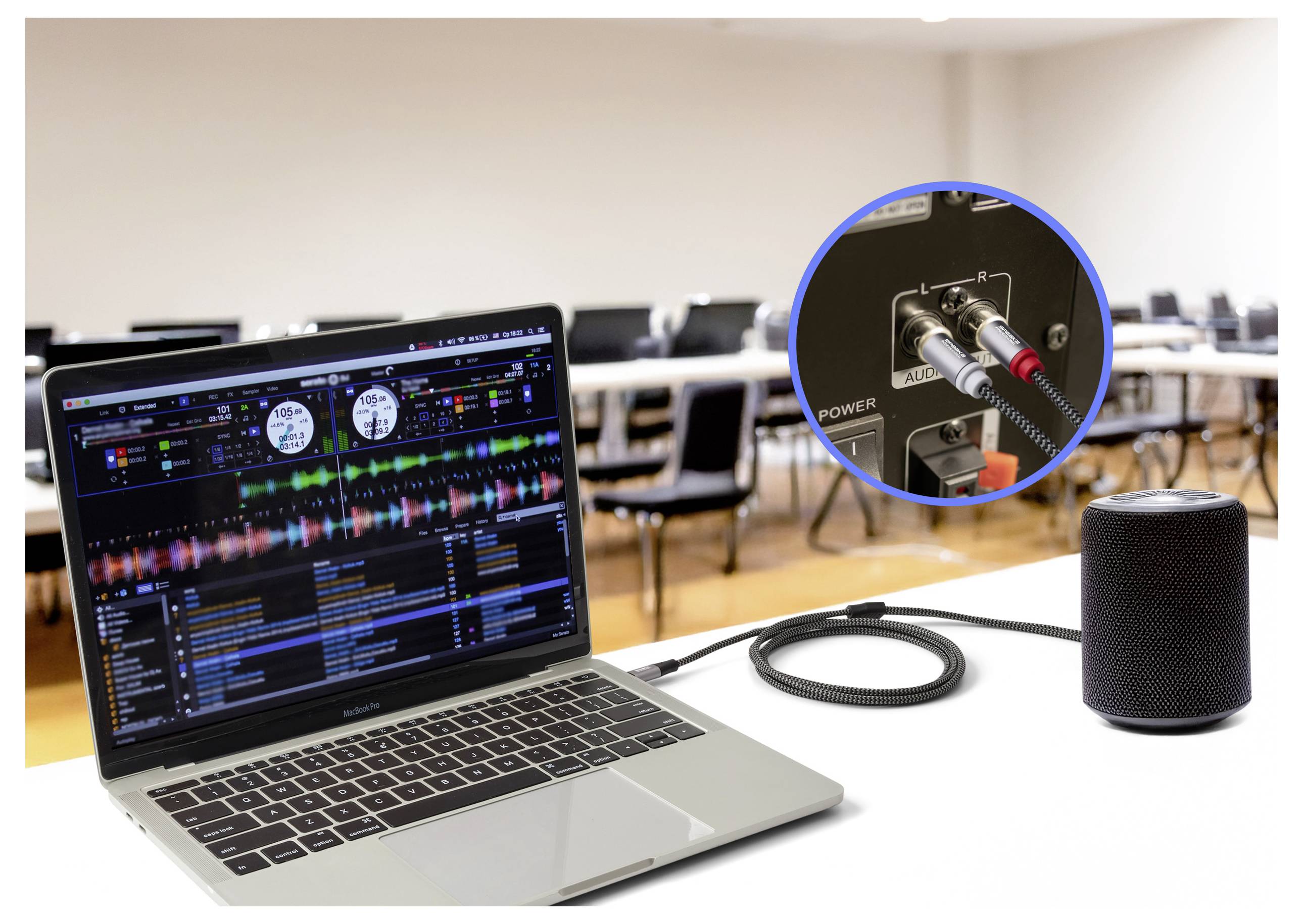 Přenosný počítač zobrazující software pro DJ je připojen k reproduktoru ve třídě. Vložený obrázek ukazuje audio kabely zapojené do zadního panelu reproduktoru.