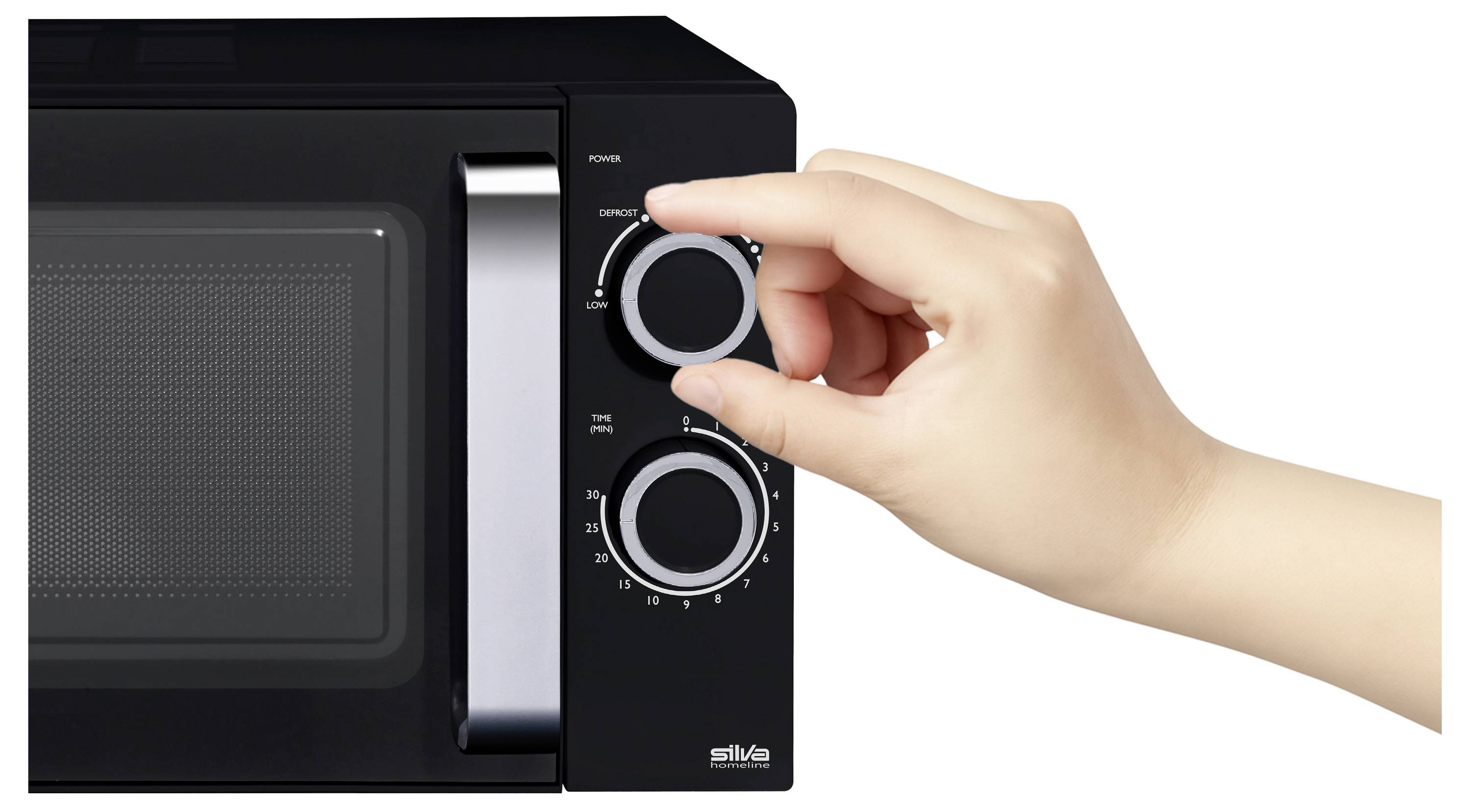 Ruka nastavuje časový spínač černé mikrovlnné trouby. Mikrovlnná trouba má knoflík pro nastavení výkonu a viditelnou mřížku na dvířkách.
