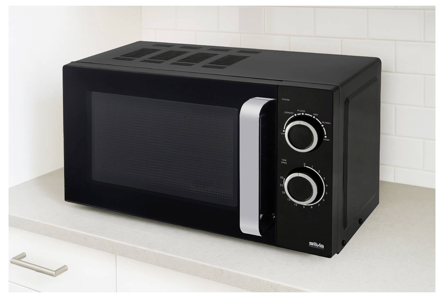 Černá mikrovlnná trouba se dvěma kruhovými ovládacími kolečky stojí na kuchyňské lince před bílým obkladem.