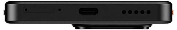 Černý elektronický přístroj pohledem z boku, vybavený portem USB-C a několika malými otvory pravděpodobně pro reproduktor nebo mikrofon.