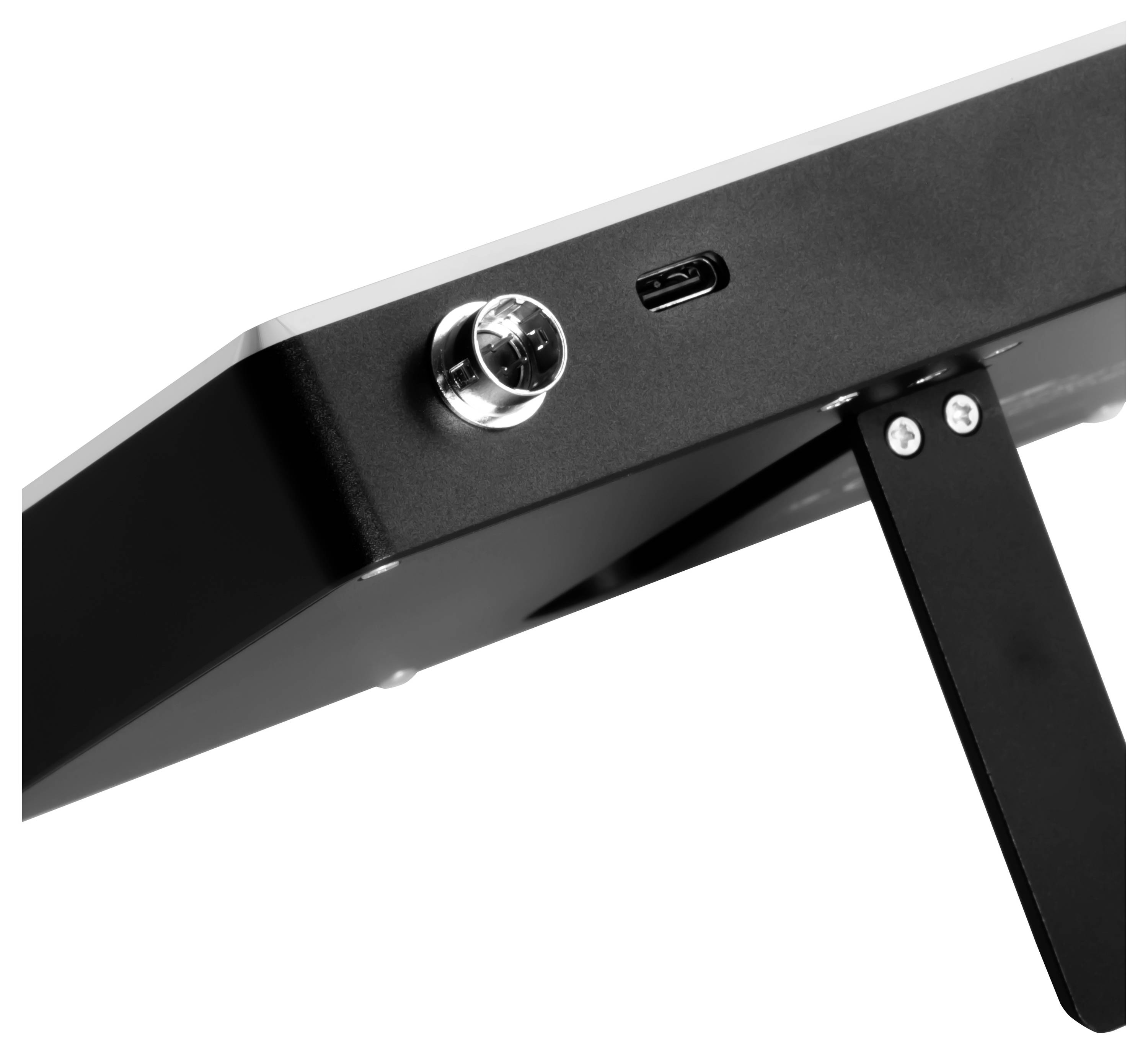 Detailní záběr černého elektronického zařízení s portem USB-C, kulatým regulačním knoflíkem a sklopným stojánkem na bílém pozadí.
