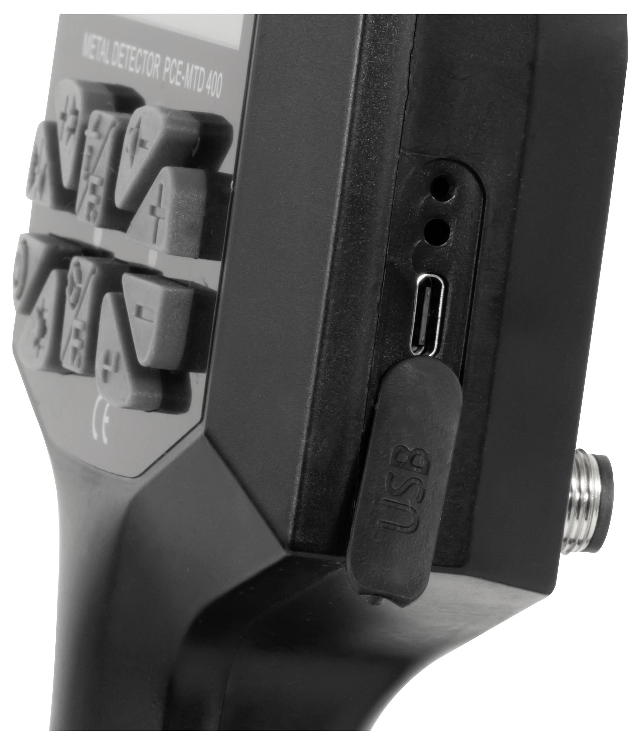 Detailní záběr na černé elektronické zařízení s popsanými tlačítky a zakrytým USB portem na straně.