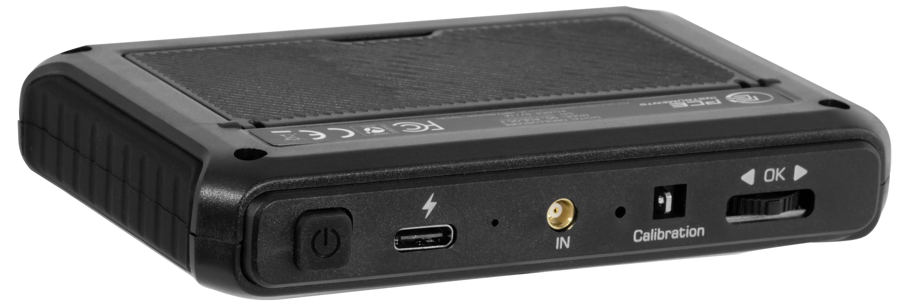 Černé elektronické zařízení s tlačítkem napájení, portem USB-C, vstupním jack konektorem a kalibračním přepínačem na přední desce.