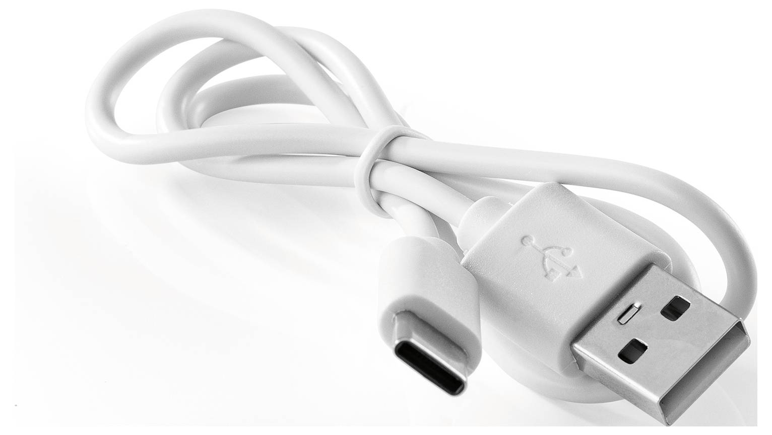 Bílý kabel USB-C na USB-A pro nabíjení, svinutý a ležící na bílém povrchu, ukazující oba konektory.