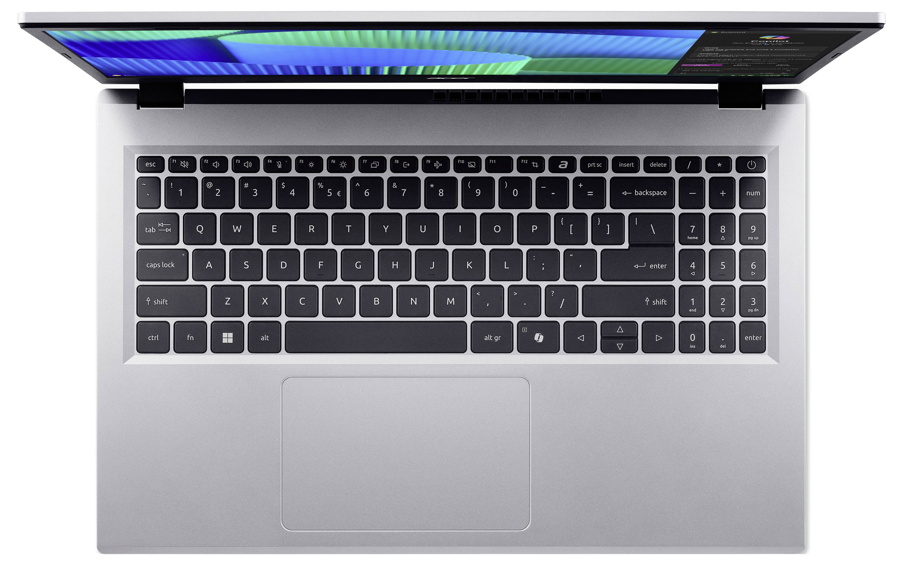 Stříbrný laptop pohledaný shora, zobrazující plnou klávesnici s dotykovým polem pod ní a částečně viditelnou osvětlenou obrazovkou.