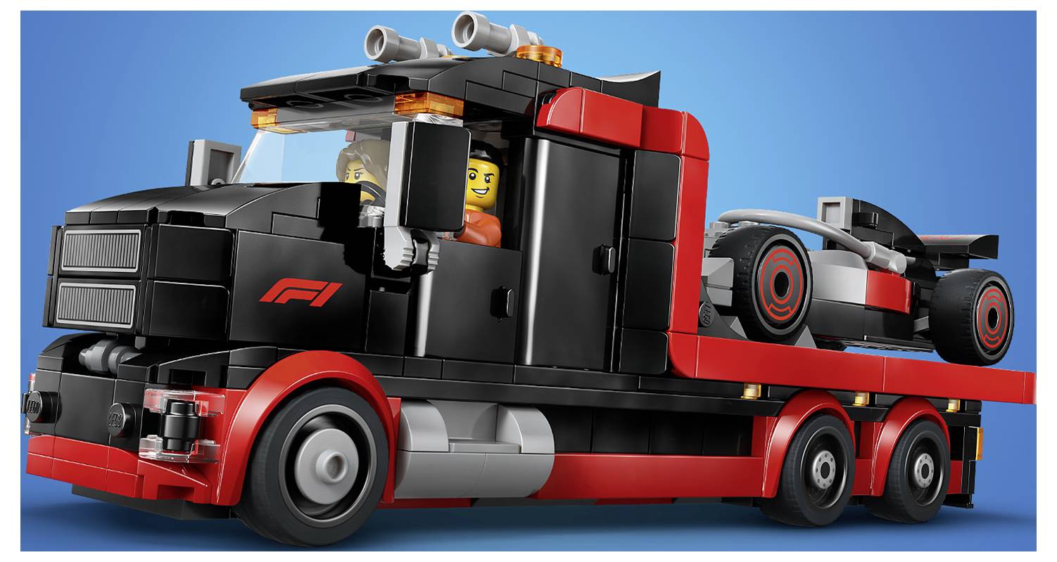 Plastikový LEGO nákladní vůz s logem "F1" vezoucí závodní auto na své plošině. Dva LEGO panáčky sedí v kabině nákladního vozu. Modrý pozadí.