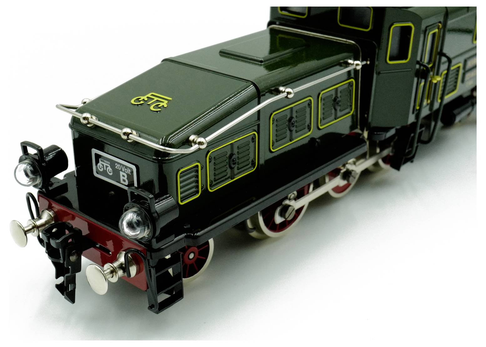 Vintage zelená modelová parní lokomotiva s ozdobnými detaily a červenými koly, na přední desce vyznačená písmenem 'B' a 'D.B. 20V'.