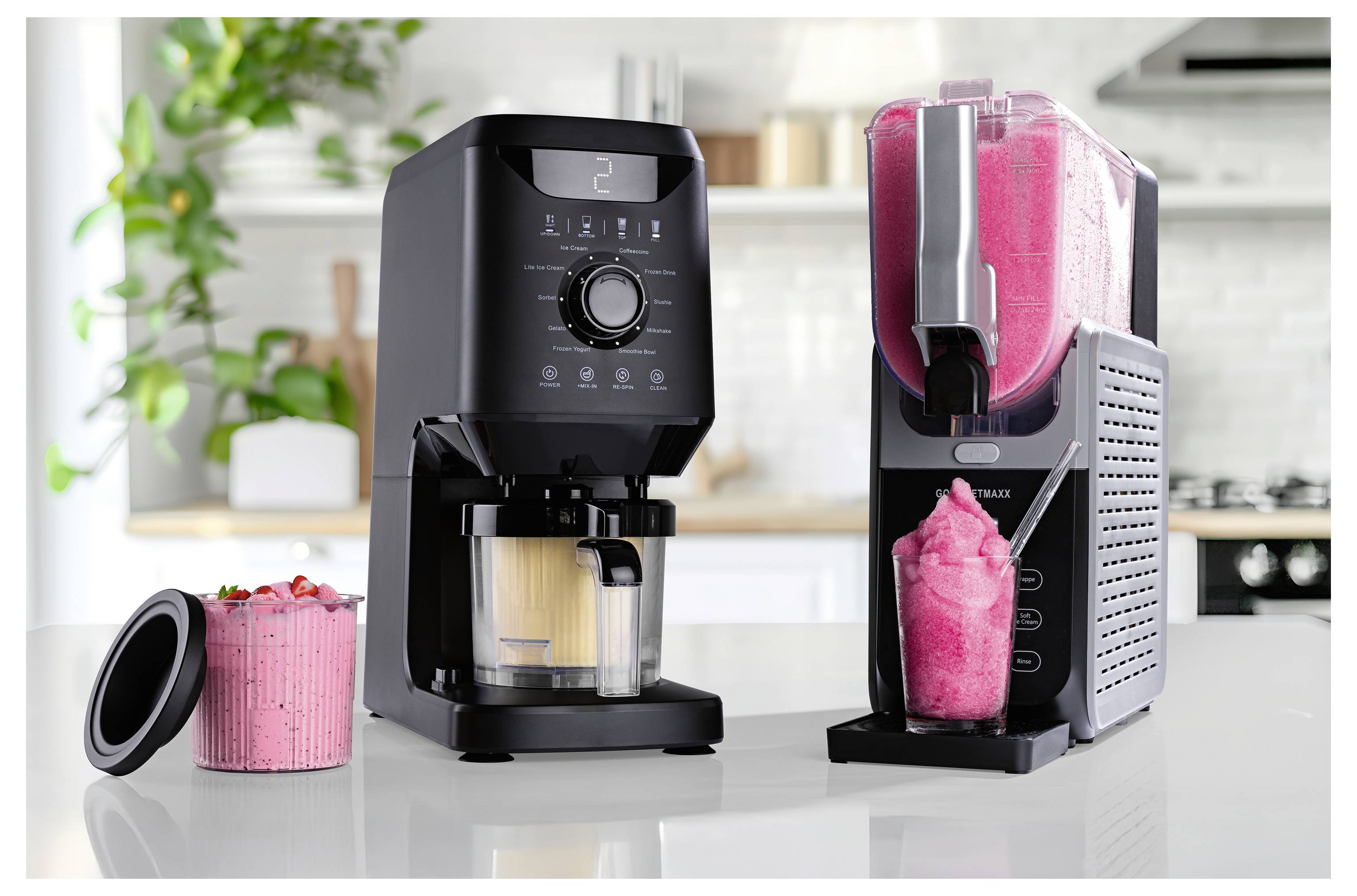 Elegantní černý kávový stroj s digitálními ovládacími prvky a mixér naplněný jasně růžovým smoothie na kuchyňské lince, rostliny v pozadí.