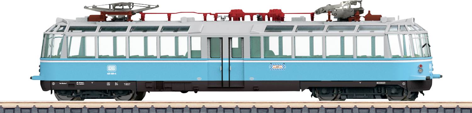 Modrý vintage model železničního vozu se zjednodušeným designem, opatřený velkými okny a horním elektrickým vybavením, vystavený na trati.