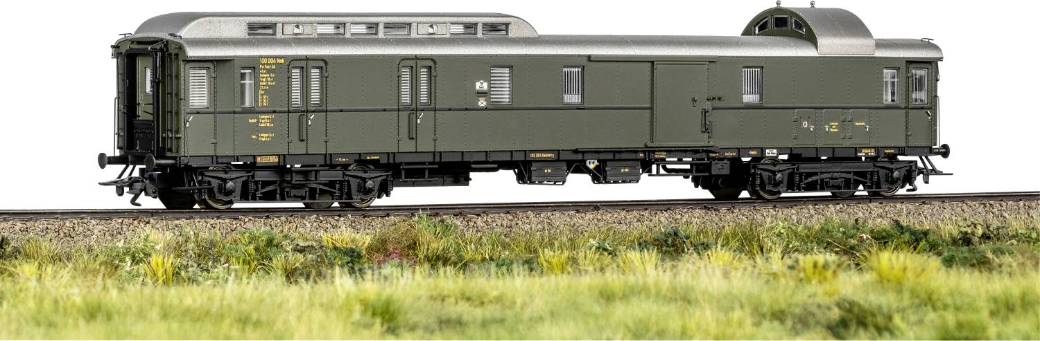 Modelový vagon vlaku v zelené barvě s detailními značkami stojí na kolejnici, obklopen trávou, čímž předvádí jemné řemeslo.