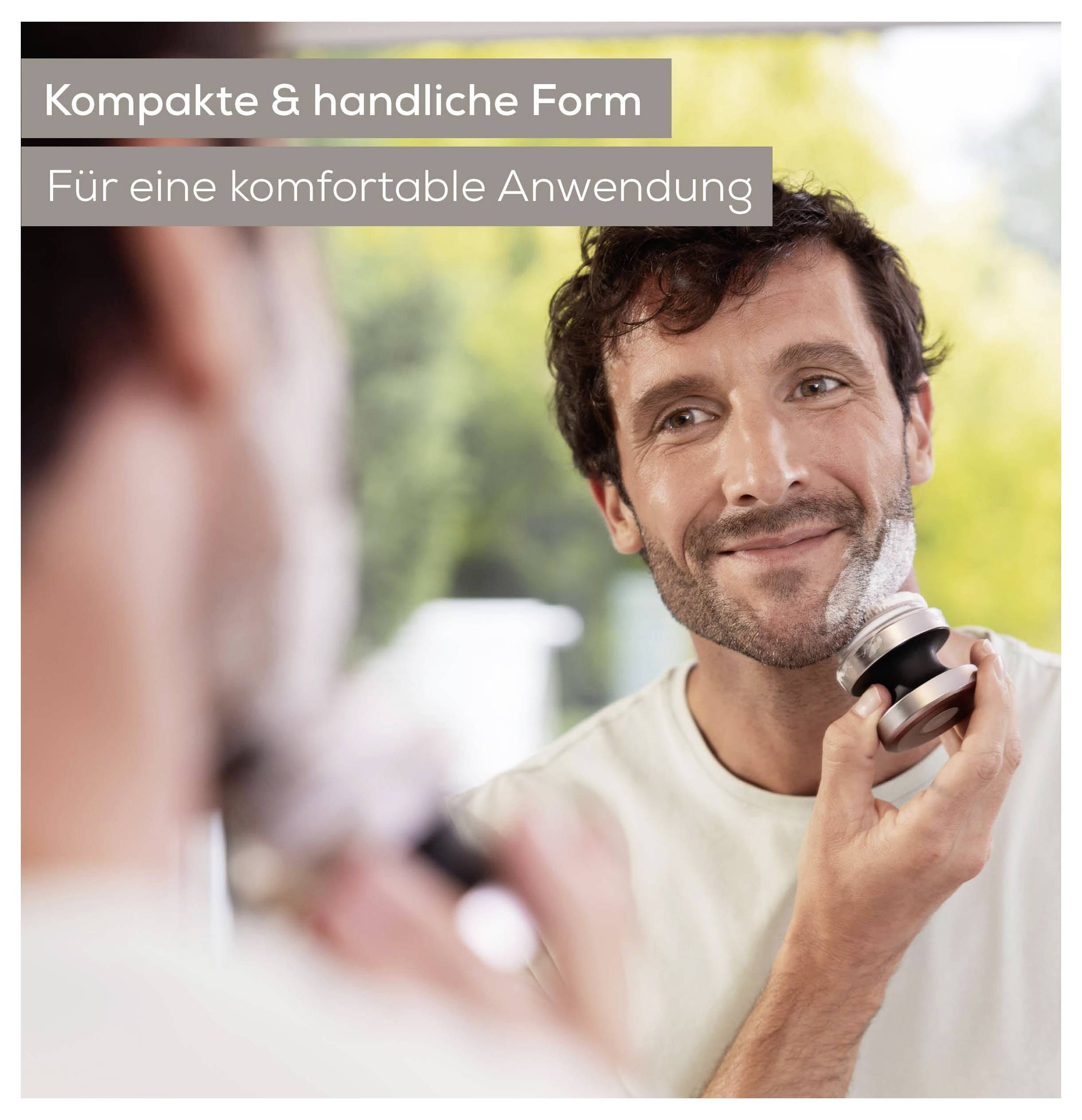 Muž se usměje při používání elektrického holícího strojku před zrcadlem. Text zní „Kompaktní a ergonomická forma" a „Pro pohodlné použití".