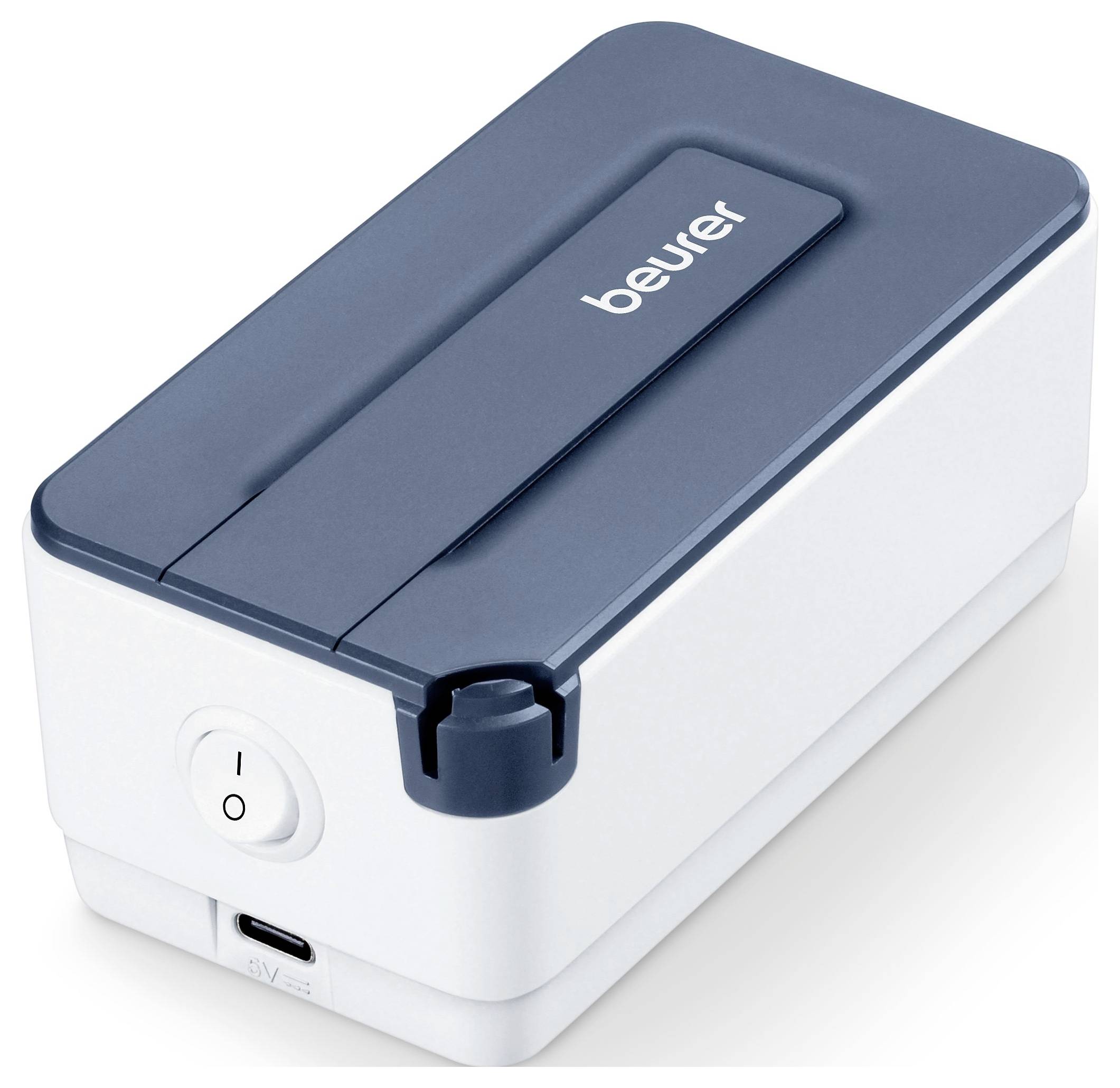 Kompaktní bílé a šedé zařízení Beurer s tlačítkem napájení, USB portem a logem "beurer" na horní straně, navržené pro přenosnost.