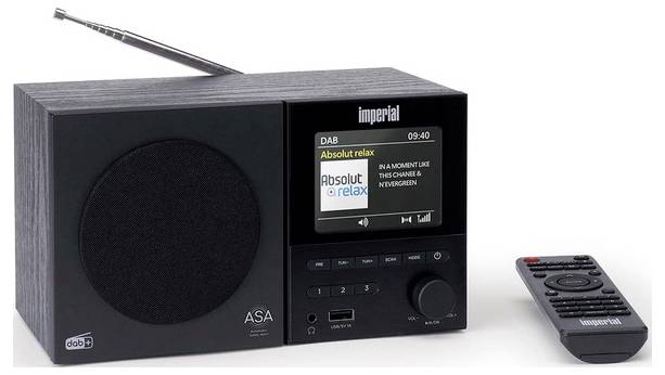 Digitální rádio s displejem zobrazujícím "Absolut relax", vedle dálkového ovladače. Rádio má tlačítka pro ladění a anténu.
