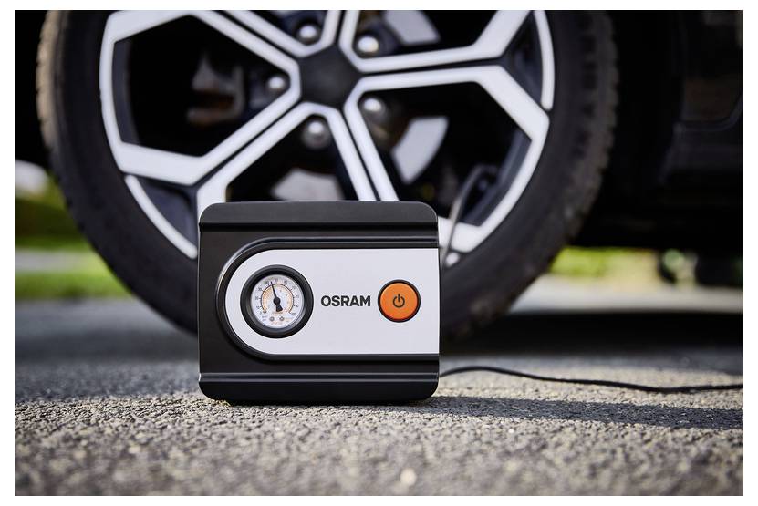 Zařízení k plnění pneumatik značky "Osram" je umístěno na zemi před pneumatikou automobilu a zobrazuje manometr a tlačítko napájení.