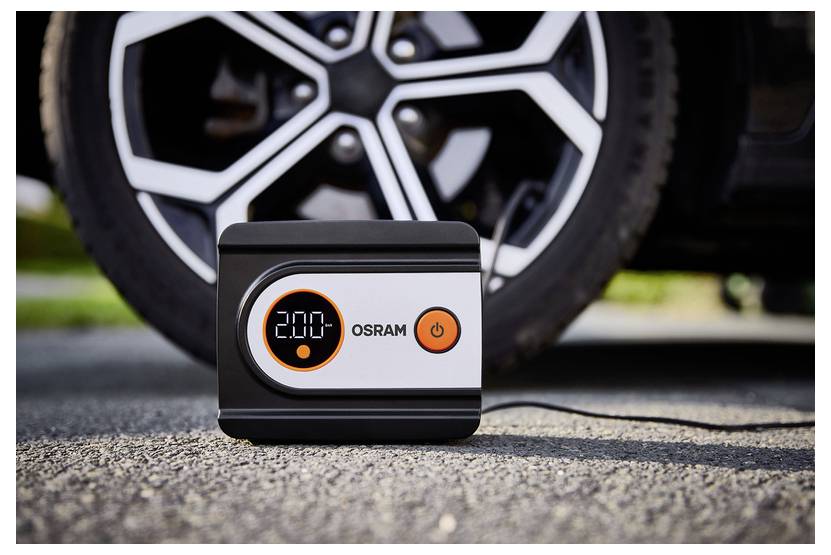 Digitální tlakový manometr se vzduchem ukazující na displeji "2,00" je umístěn na zemi před pneumatikou automobilu a je připraven k použití.