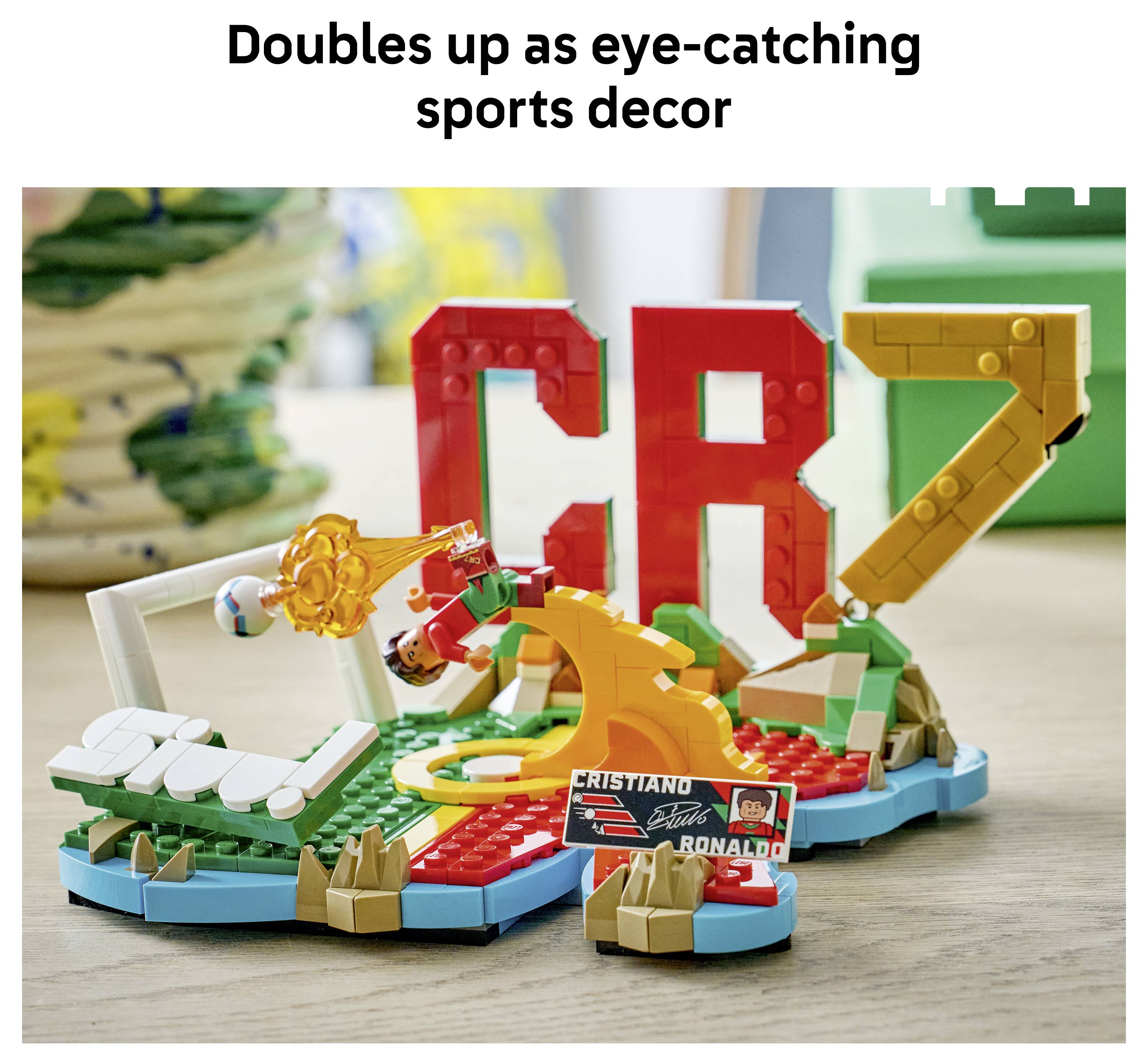 LEGO-style sportovní display s velkými červenými písmeny CR7 a fotbalovou scénou, pod textem „Dvojí využití jako upoutávající sportovní dekorace".