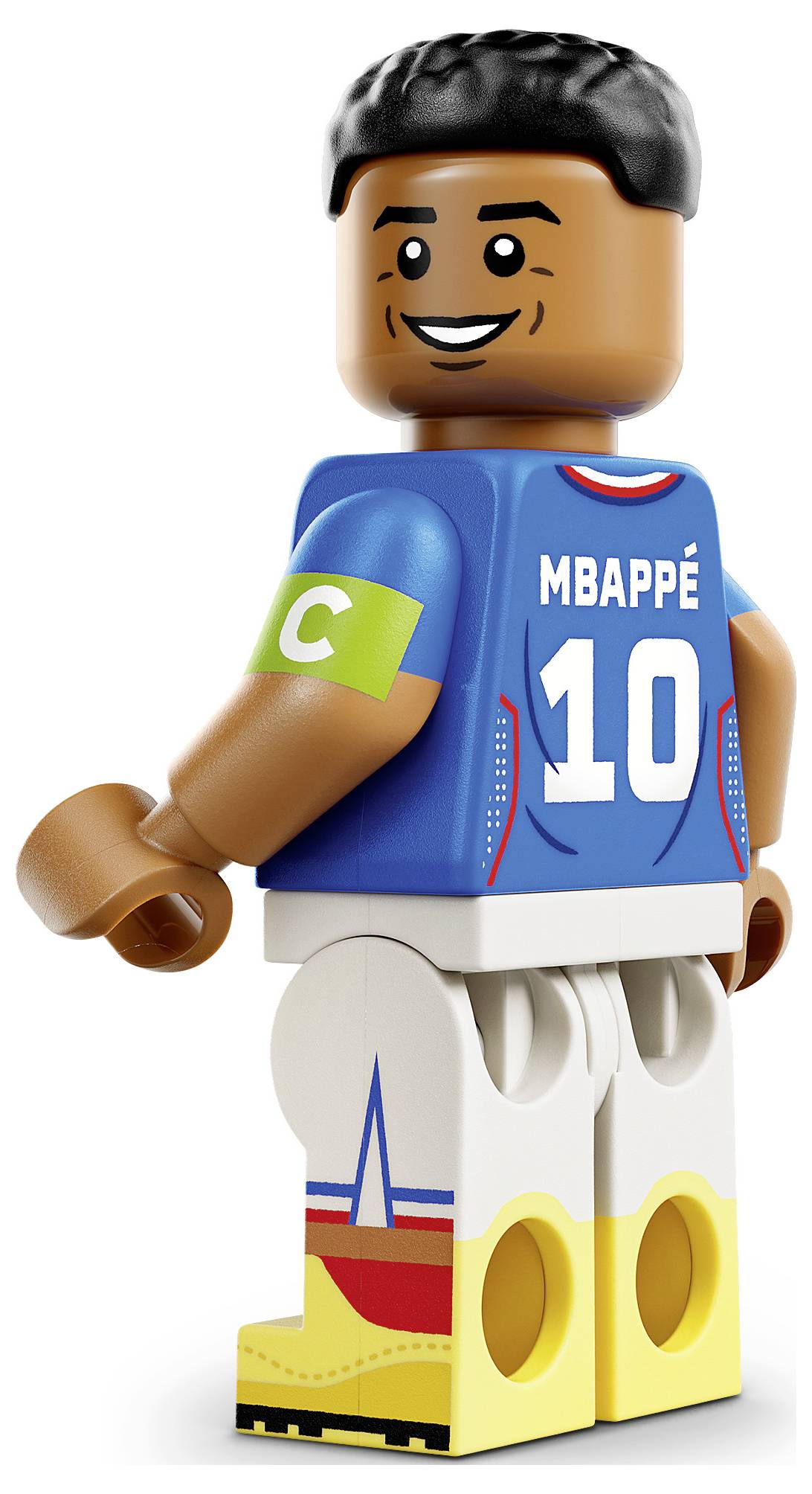LEGO stylu miniaturní figurka fotbalisty Mbappého v modrém francouzském dresu s číslem 10 a kapitánskou páskou, stojící na bílém pozadí.