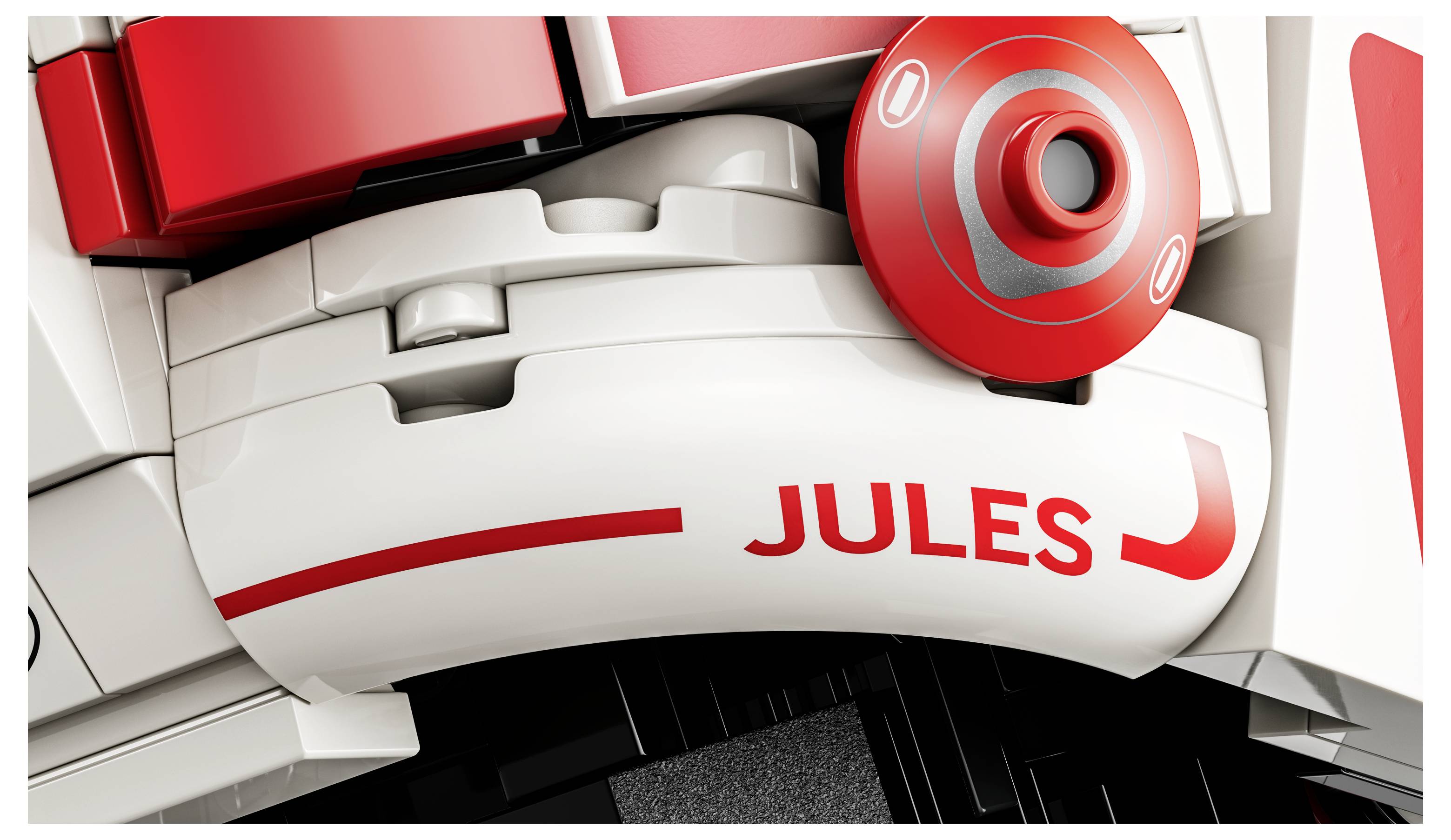 Detailní záběr na dílky LEGA s červeno-bílým designem, na kterých je vytištěno jméno 'Jules' červenou barvou.