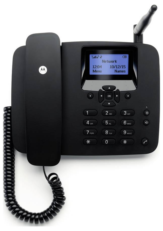 Černý kancelářský telefon "Motorola" se sluchátkem a spirálovým kabelem, digitální displej zobrazující název sítě, datum "10/12/15", čas "12:04".