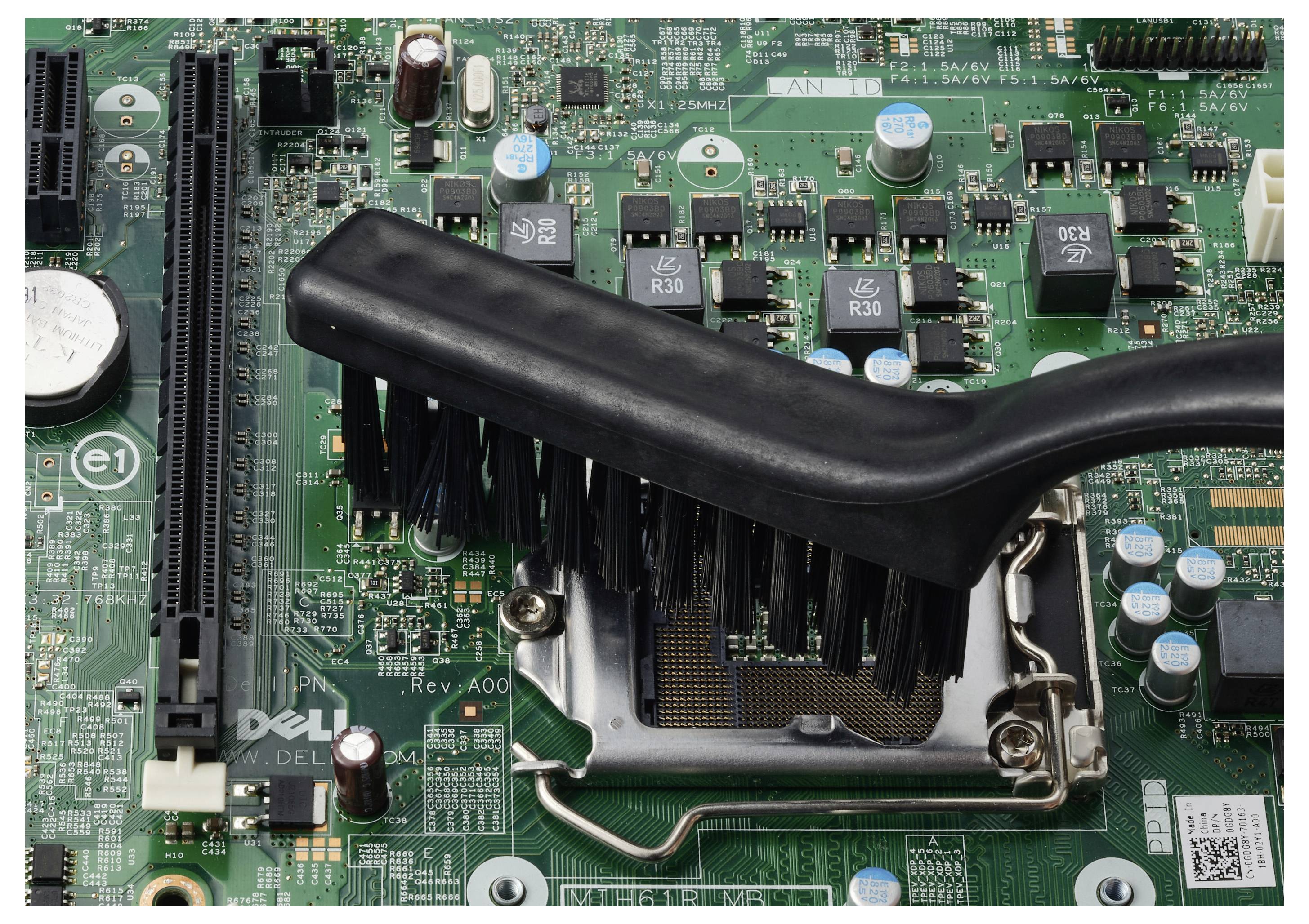 Detailní pohled na Dell základní desku s socketem CPU a nainstalovaným černým chladičem/ventilátorem, ukazující blízké sloty RAM a elektronické komponenty.