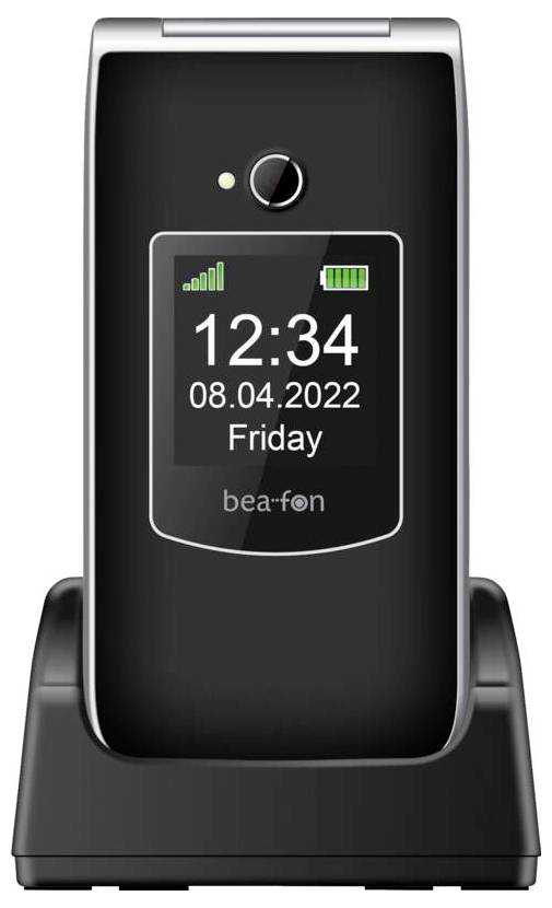Skládací telefon 'Bea-fon' na nabíjecím stojanu zobrazující na displeji '12:34, 08.04.2022, Pátek' s ikonami signálu a baterie.