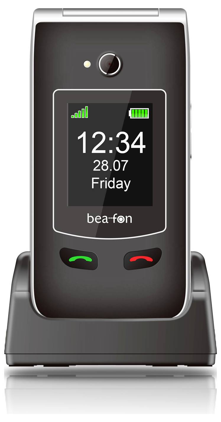 Sklopný telefon v nabíjecím stanu zobrazuje čas "12:34", datum "28.07" a den "Pátek". Dvě ikony ukazují sílu signálu a úroveň baterie.