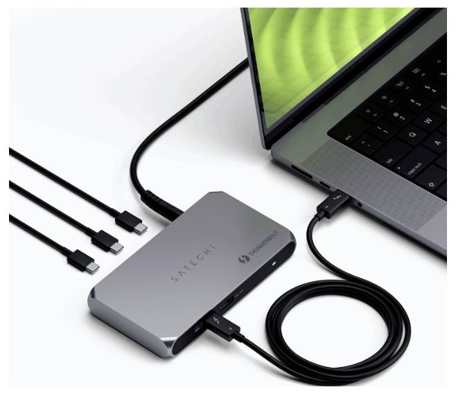 Laptop je připojen k multifunkčnímu adaptéru Satechi, který má kabely pro USB-C, HDMI a Ethernet, což znázorňuje možnosti připojení.