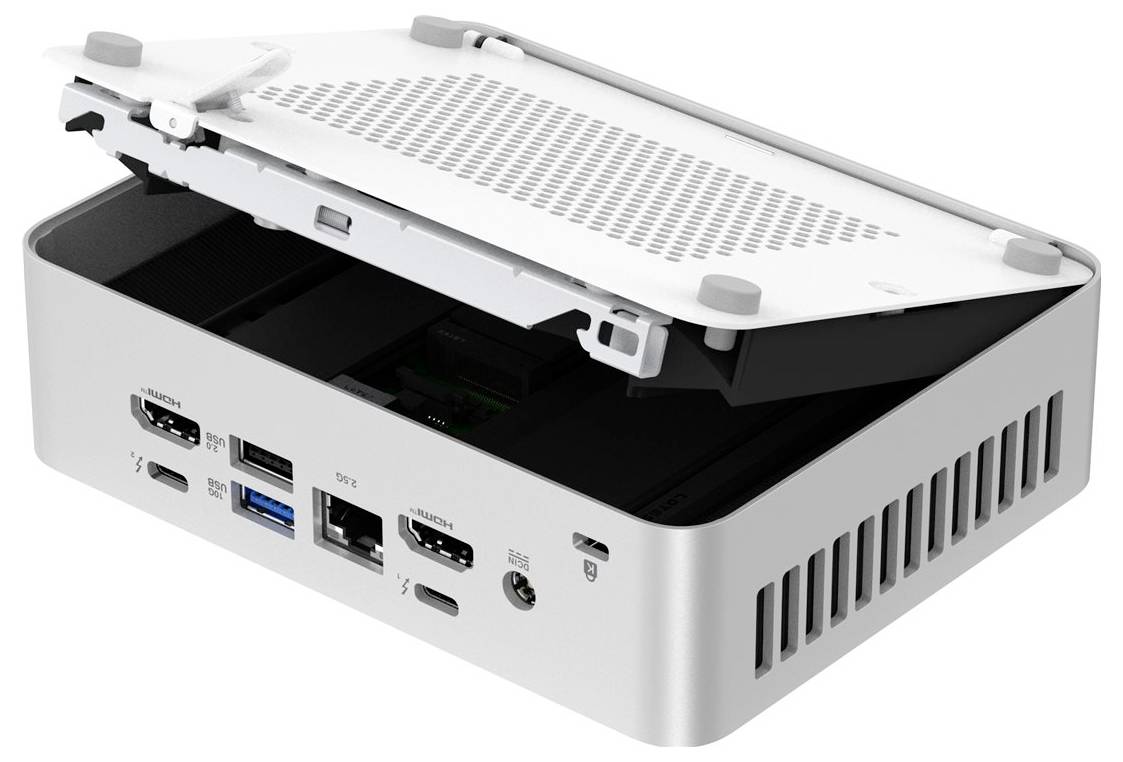 Malý počítač s otevřeným víkem zobrazující vnitřní součásti, s více porty včetně HDMI, USB a napájecího vstupu na straně.