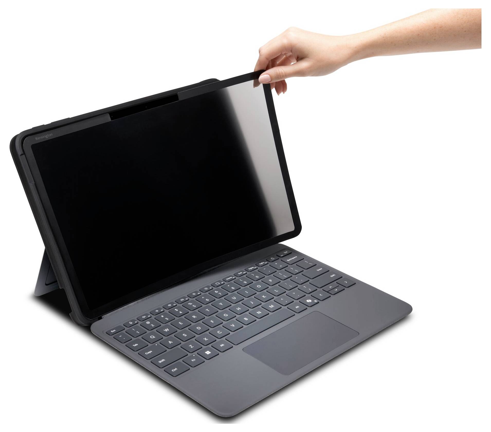 Ruka zvedá magnetickou obrazovku pro soukromí z notebooku, který je otevřený s viditelnými klávesami. Obrazovka je částečně oddělena od notebooku.