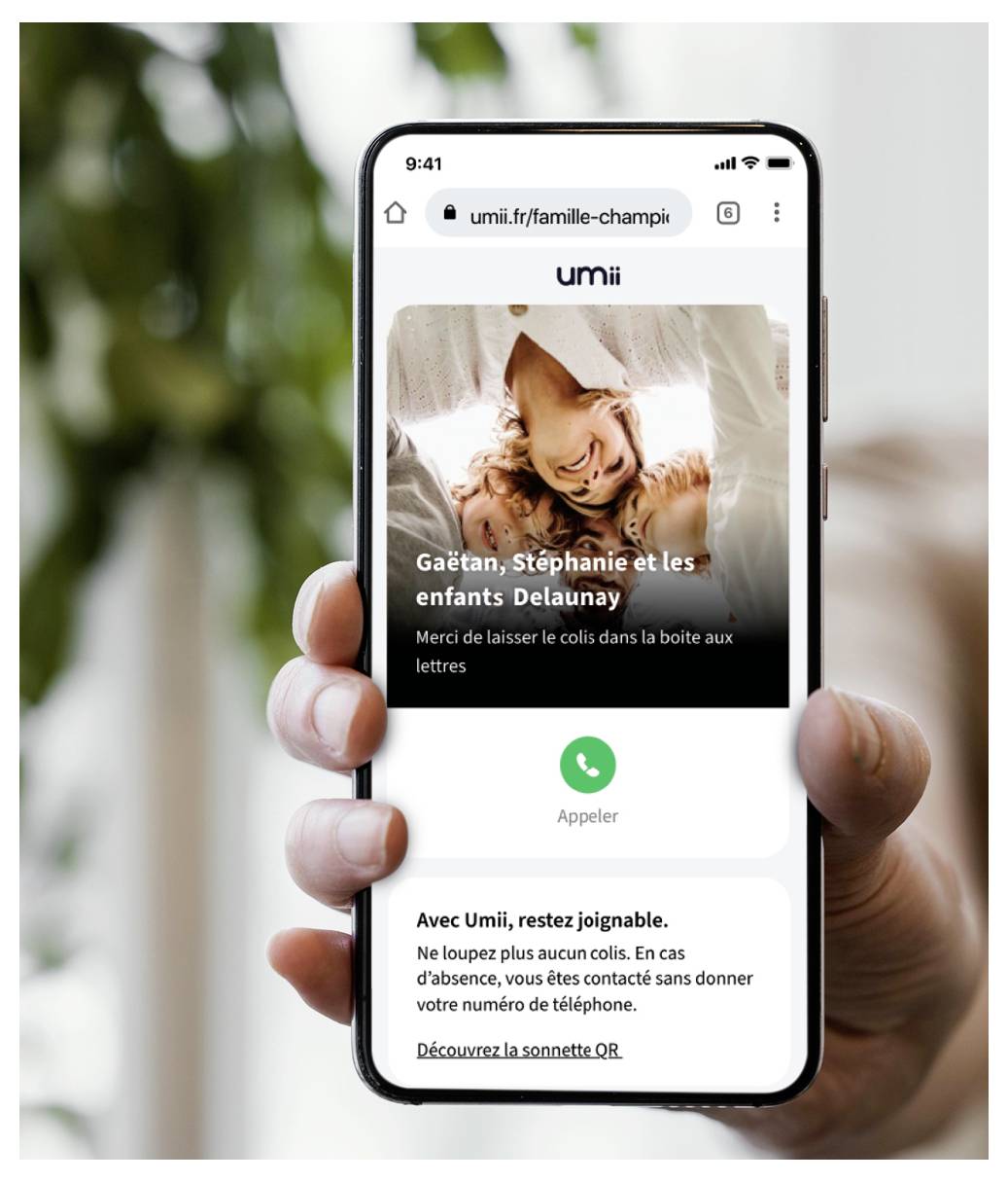 Smartphone zobrazuje webovou stránku s textem „umii" v horní části. Níže je rodinná fotografie označená „Gaëtan, Stephanie et les enfants Delaunay."