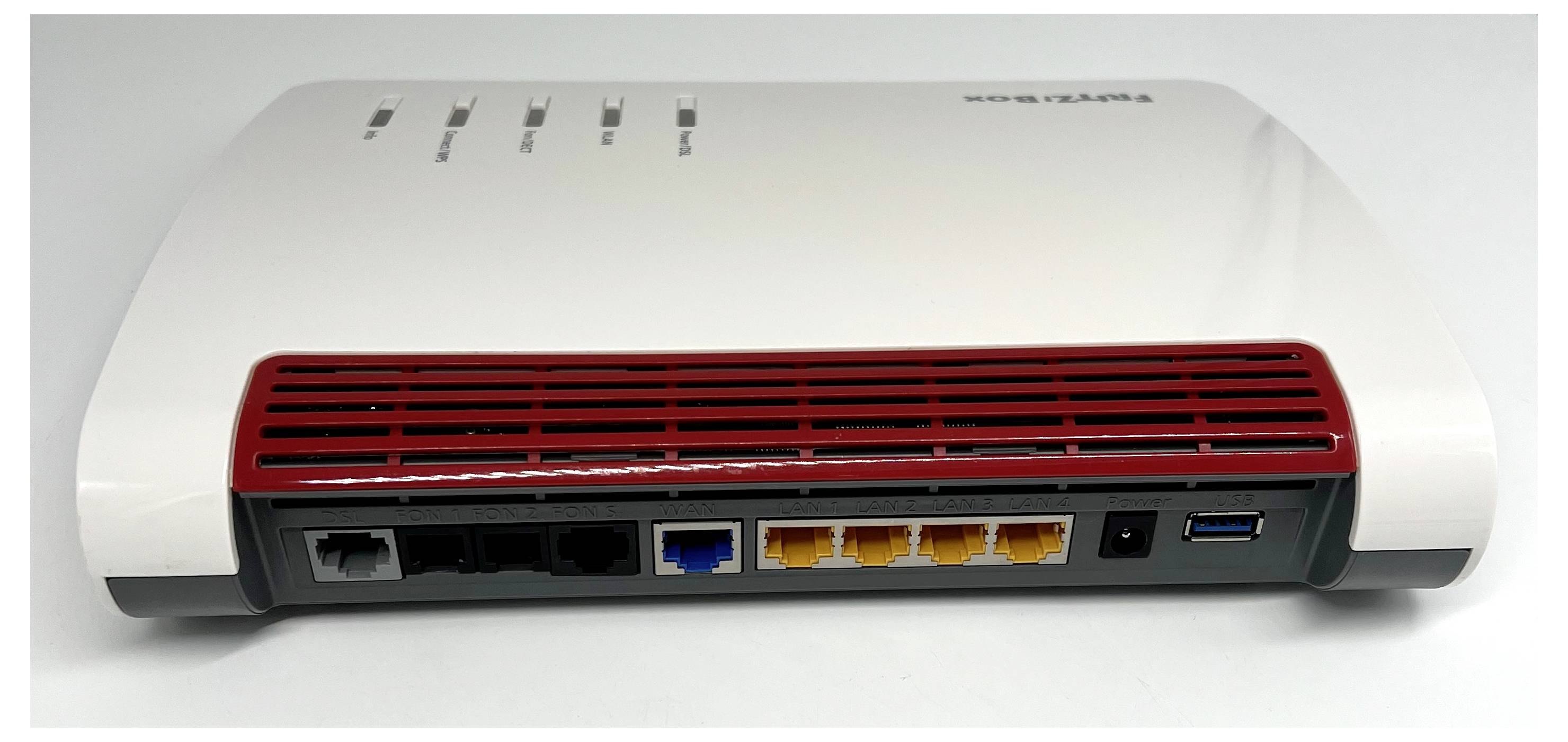 Bílý a červený LED router s více porty, včetně LAN, USB a napájecího připojení, zobrazen zezadu.