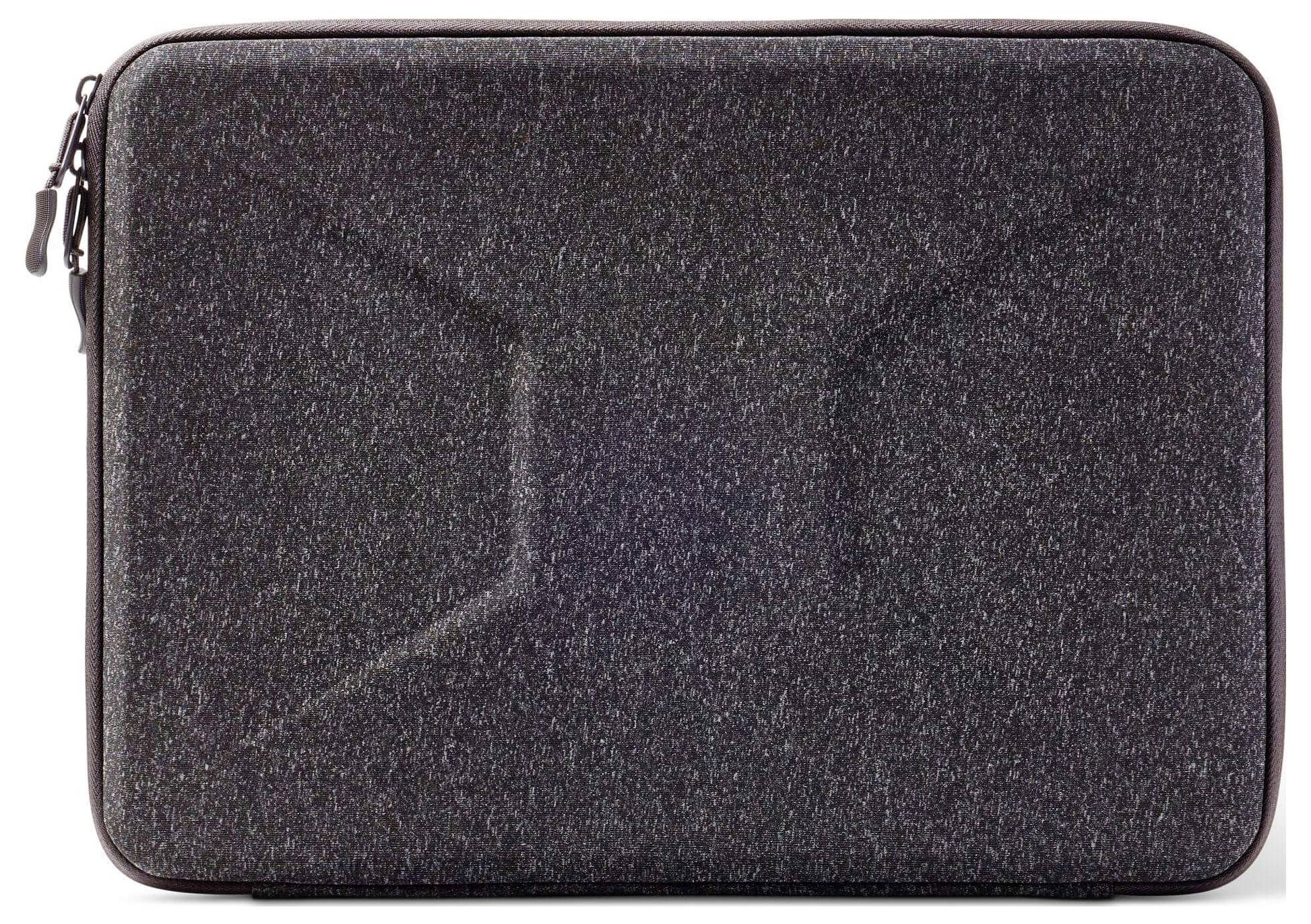 Černý obdélníkový obal na laptop s jemným úhlovitým vzorem na přední straně, viditelný zip v levém horním rohu.
