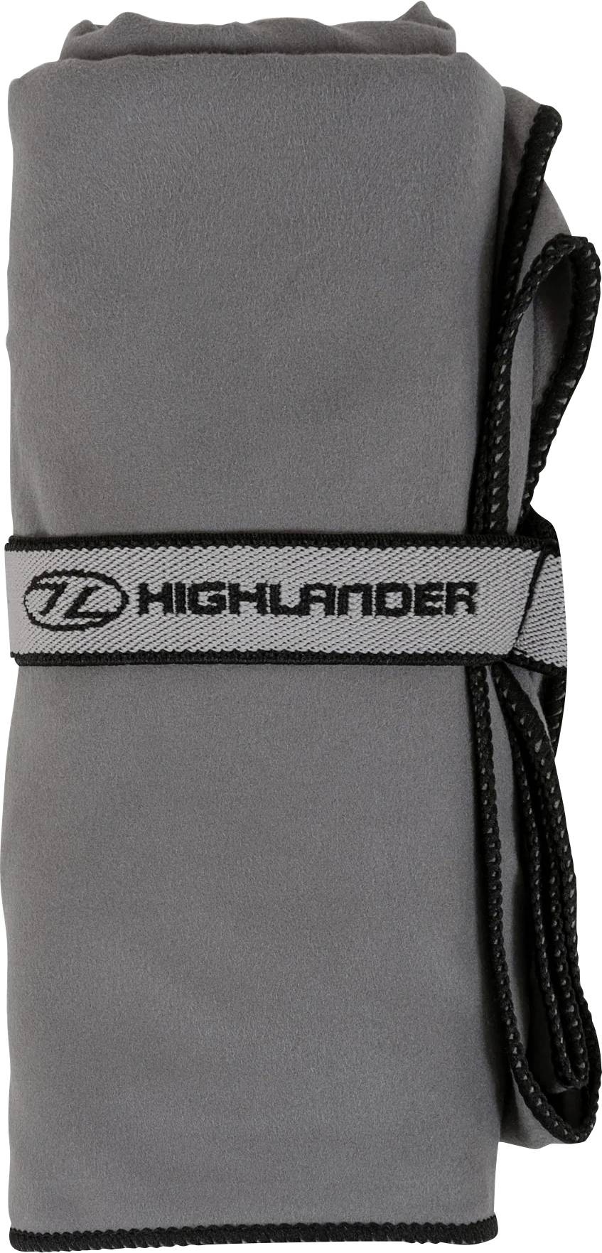 Šedý mikrovláknový ručník svinutý do role, zajištěný popruhem s logem "Highlander".