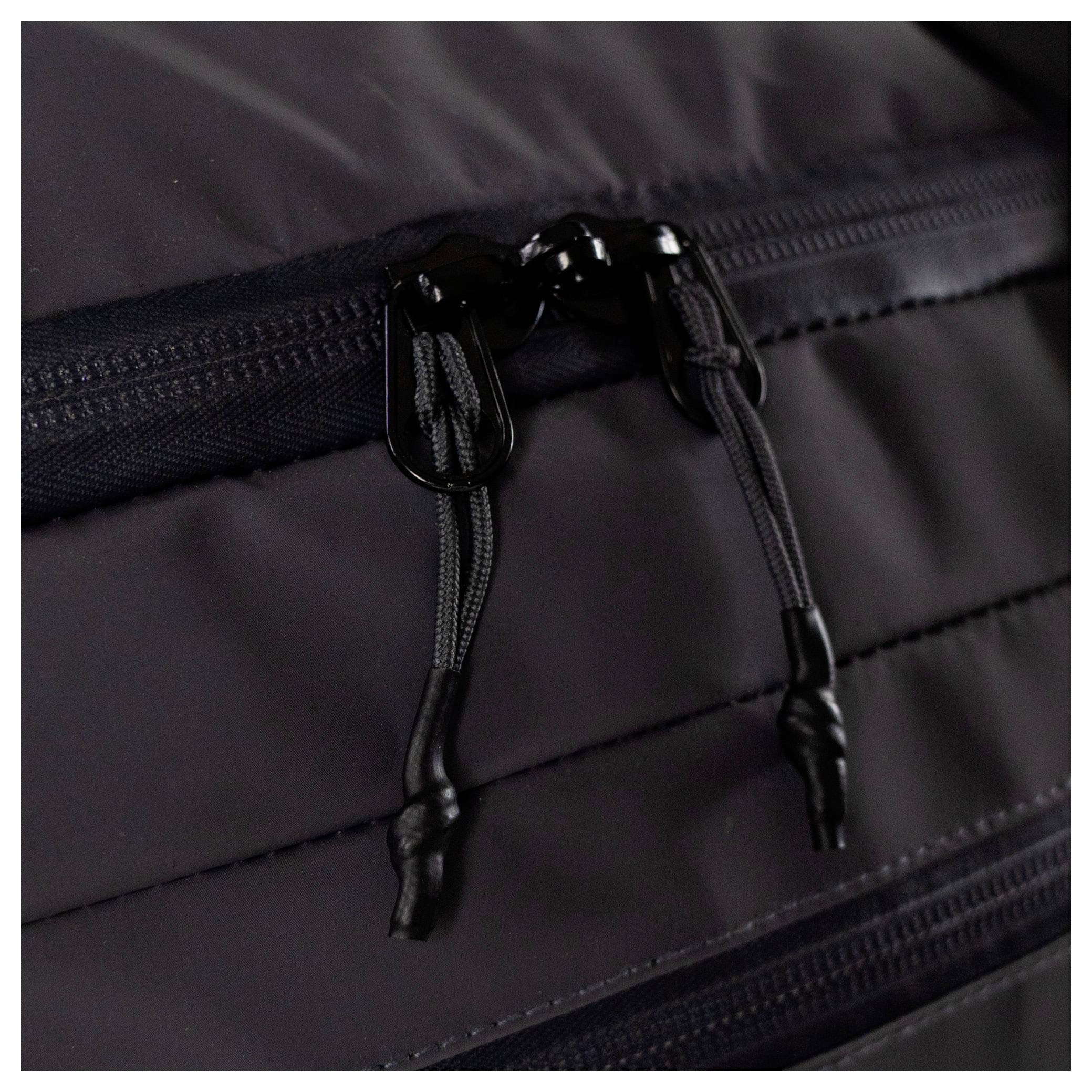 Detailní pohled na černý zip se zatahováním na textilním povrchu, znázorňující detailní steh a texturu. Zip má dva táhla na zatahování.