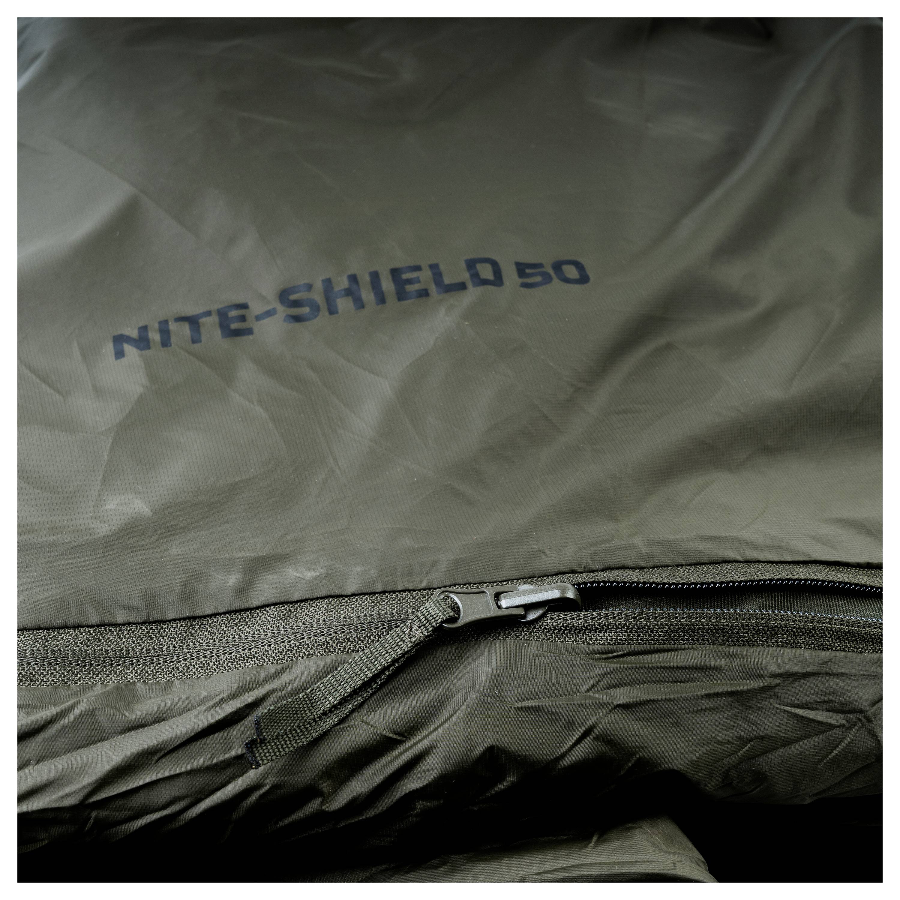Detailní záběr zelené spacího pytle se zipem, na kterém je uveden text "Nite-Shield 50".