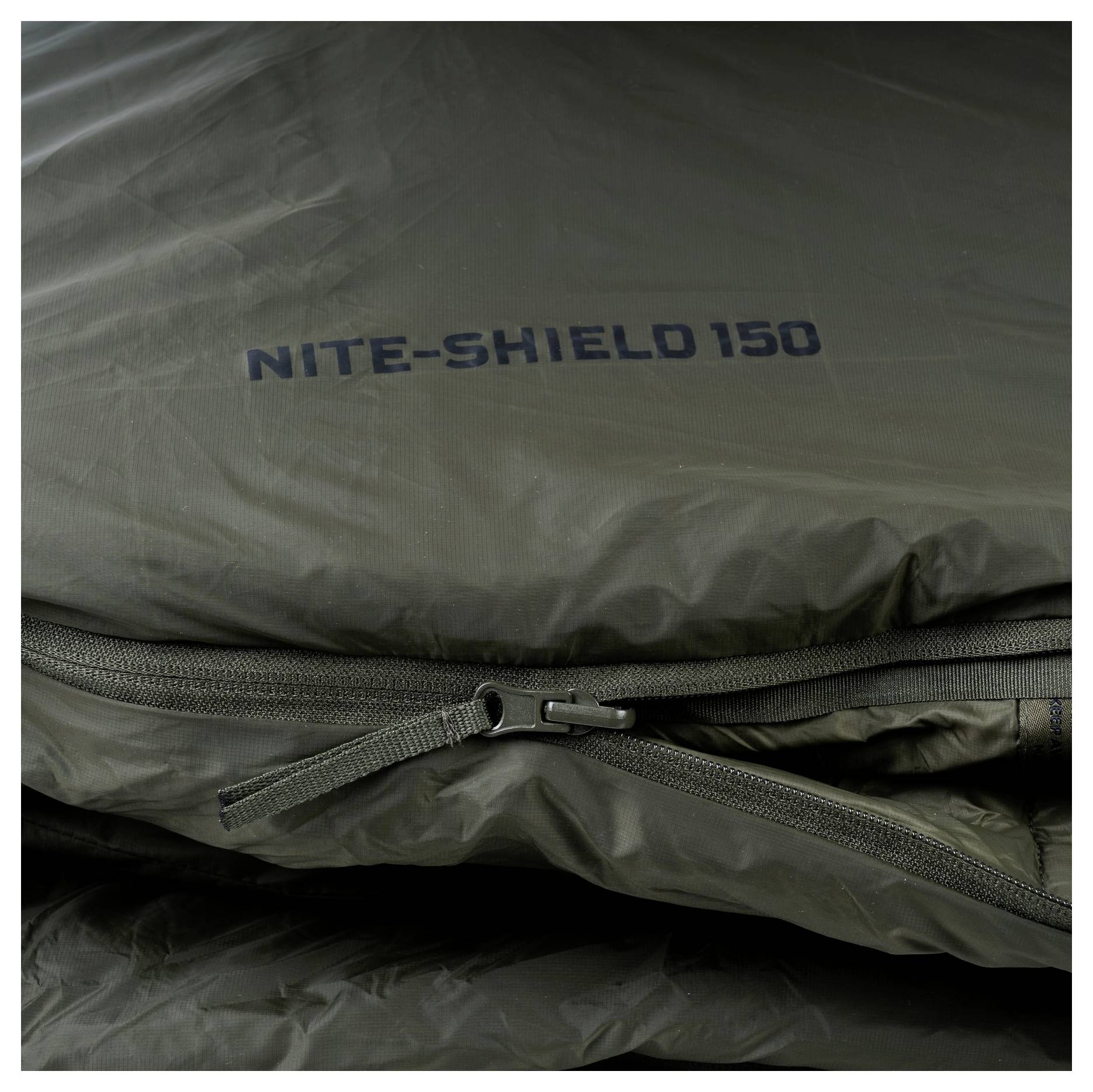 Detailní záběr sklopeného spacího pytle se zipem, označený „Nite-Shield 150".