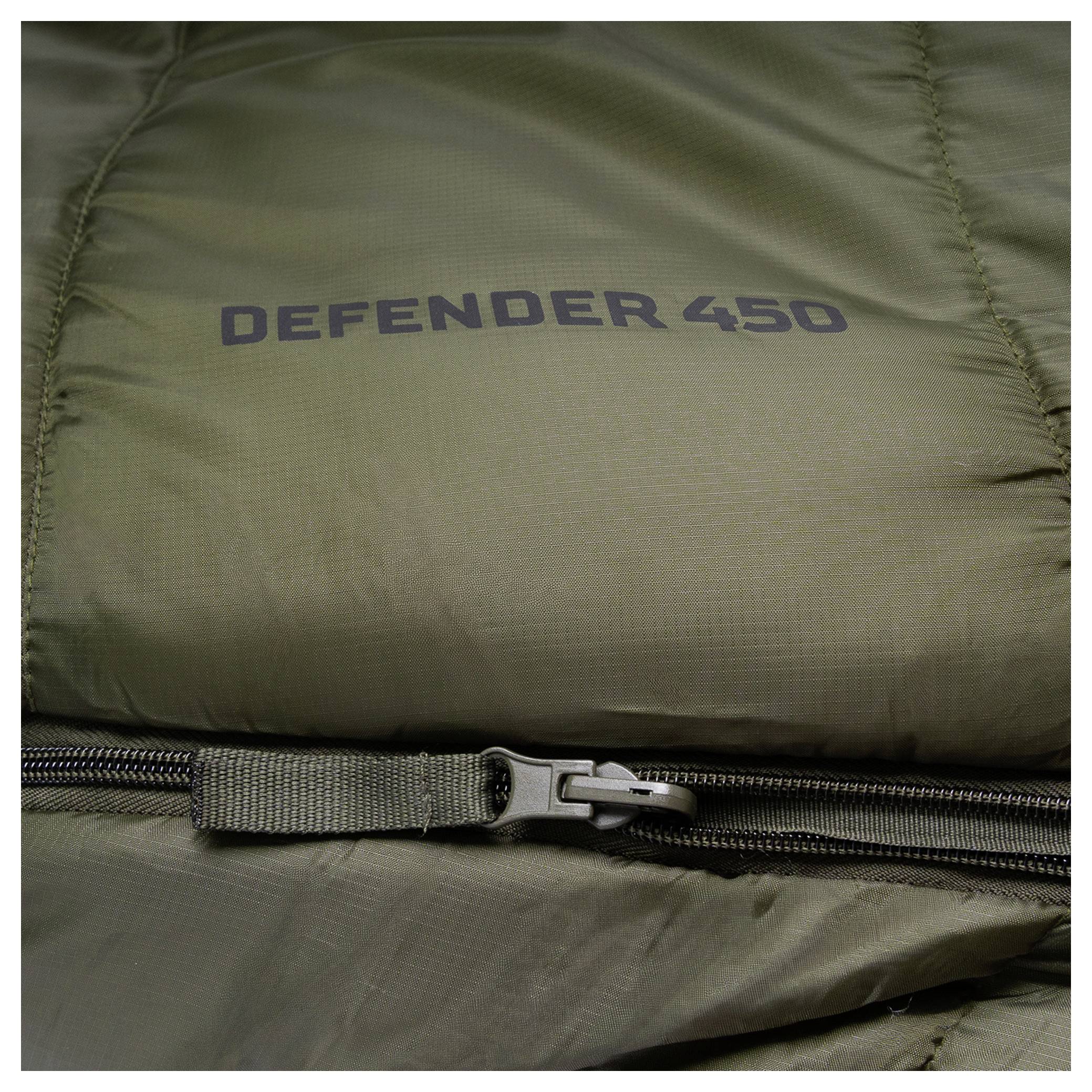 Detailní snímek zelené spacího pytle s textem "DEFENDER 450" vytištěným na něm a viditelným zipem.