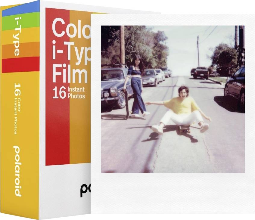 Krabička film Polaroid Color i-Type leží vedle vintage fotografie. Fotografie zobrazuje osobu sedící a pózující na skateboardu na ulici.