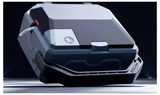 Futuristický černobílý pouzdro s tvrdou skořápkou nebo modul zařízení, zobrazený zavřený na studiové ploše s úhlovanými panely a předním západkou.