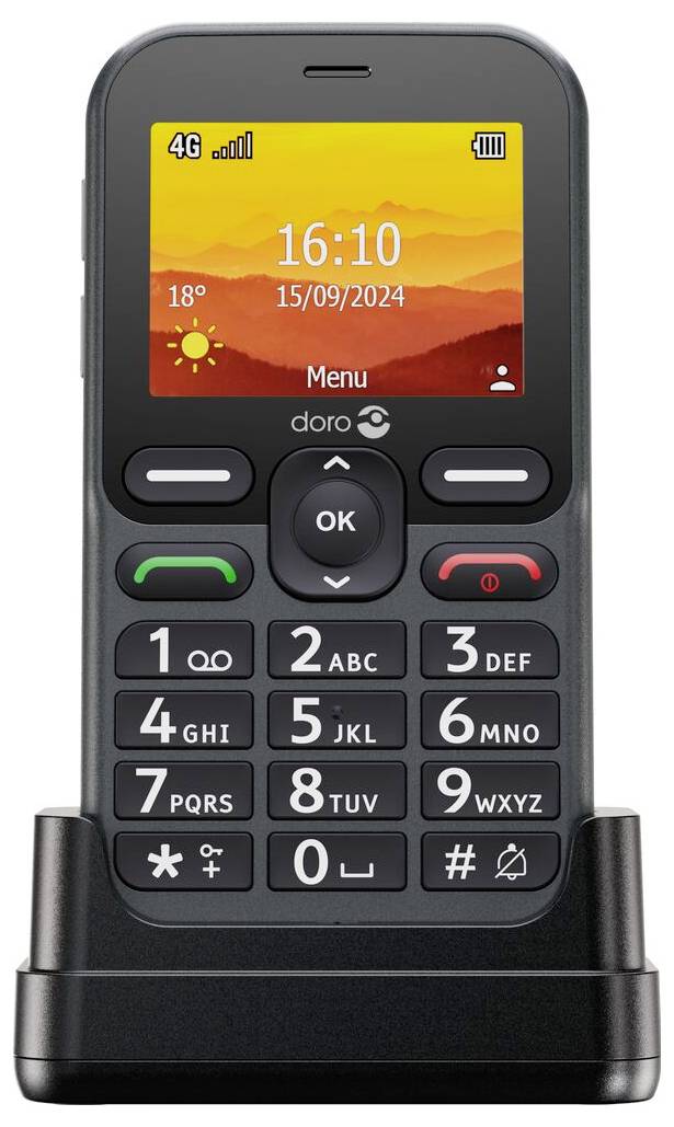 Základní mobilní telefon s barevným displejem zobrazující čas '16:10' a datum '15/09/2024', umístěný na nabíjecí stanici.