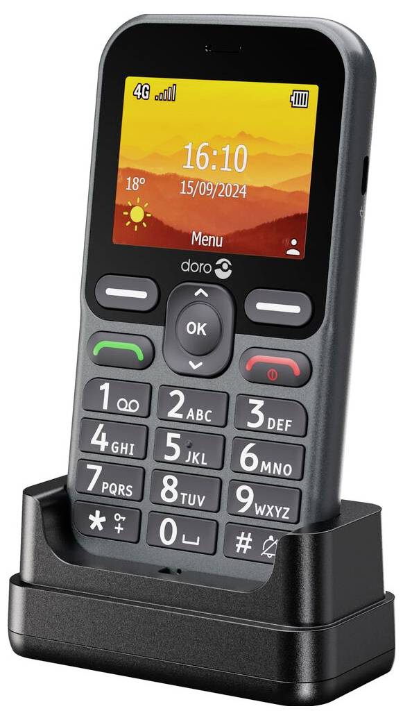 Mobilní telefon s klávesnicí a barevným displejem zobrazujícím čas '16:10' a datum '15/09/2024', umístěný na nabíjecím stojanu.