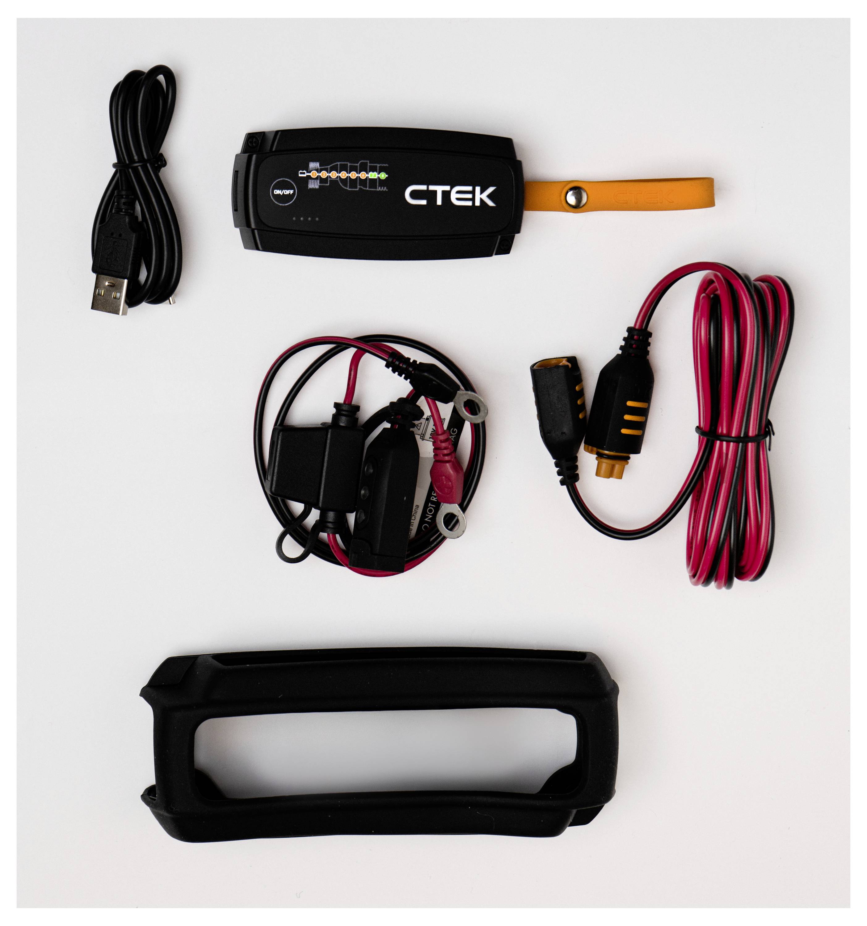 Sada nabíječky baterií CTEK s hlavním zařízením, USB kabelem, nabíjecími kabely a ochranným pouzdrem, uspořádaná na bílé ploše.