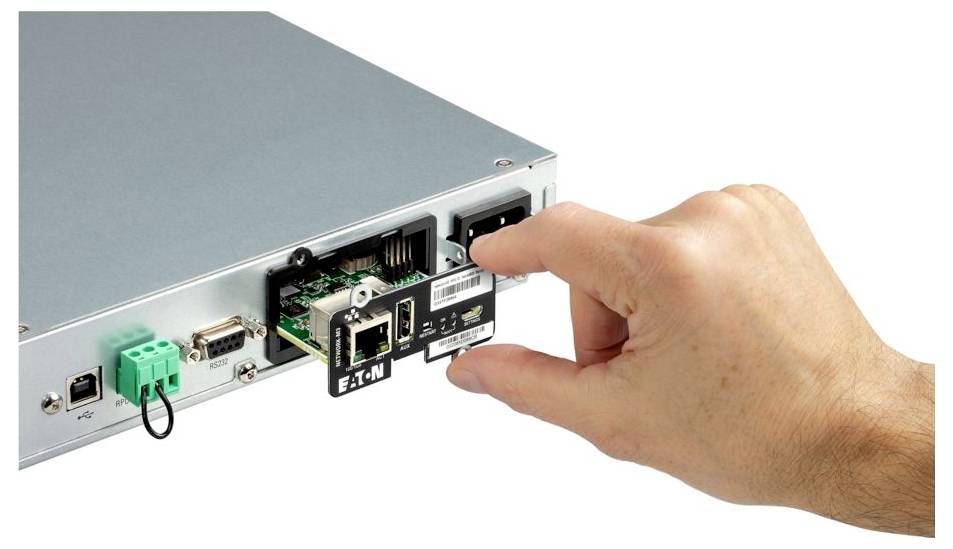 Ruka vkládající síťový modul Eaton do zadního portu stříbrného serveru nebo průmyslového zařízení.