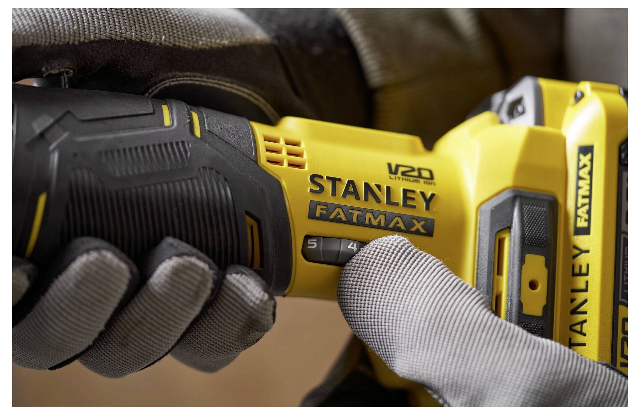 'Rukavovaná ruka drží stavební nářadí Stanley Fatmax V20, které vykazuje nastavení rychlosti a ergonomický design.'