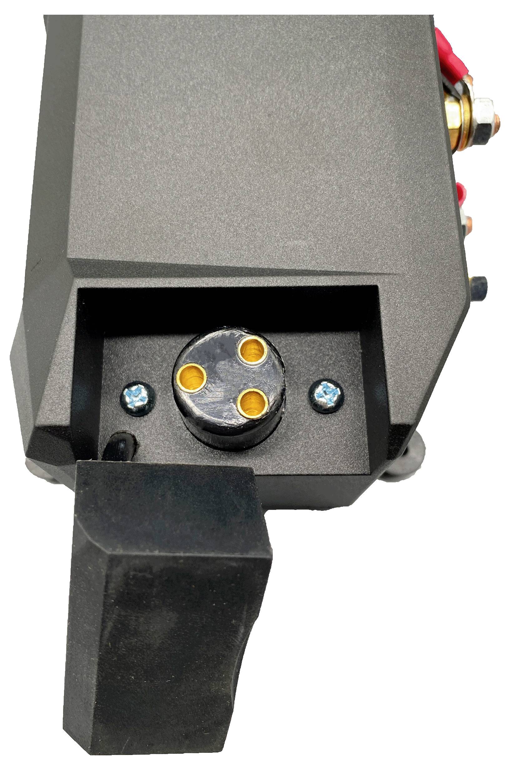 Detailní snímek černého elektronického zařízení s kulatým třípólovým konektorem a vyčnívajícím obdélníkovým krytem, zobrazený na bílém pozadí.