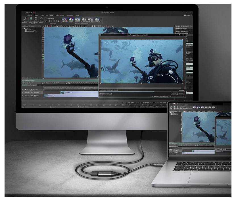 Stolní počítač a notebook zobrazující software pro úpravu videa s podvodním potápěčem a žraloky na náhledových obrazovkách.