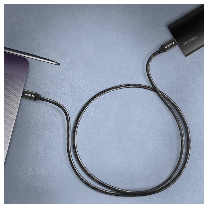 Přenosný počítač připojený k externí jednotce nebo rozbočovači AXAGON pomocí pleteného kabelu USB na modrém pozadí.
